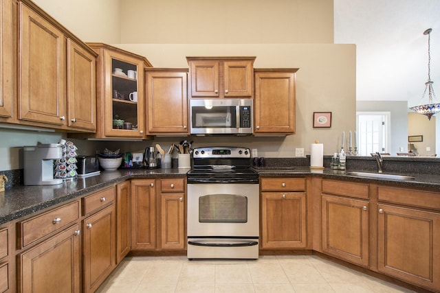 933 Bridge Crest Dr SE, Ada, MI 49301 - kitchen featuring stainless steel appliances, a sink, brown cabinets, and glass insert cabinets