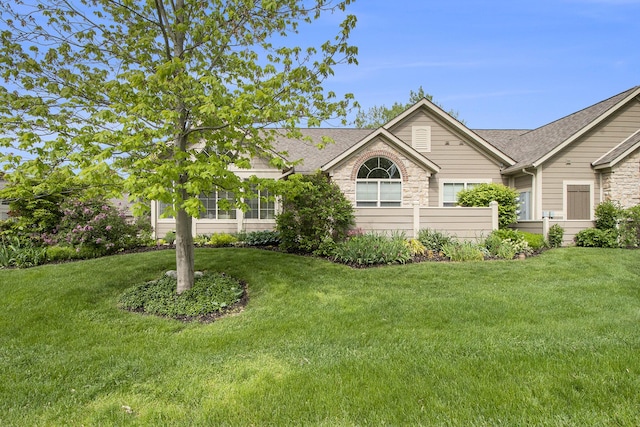 933 Bridge Crest Dr SE, Ada, MI 49301 - single story home with a front yard, roof with shingles, and stone siding