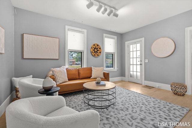 1000 Garfield Ave NW, Grand Rapids, MI 49504 - living room with wood finished floors, rail lighting, and plenty of natural light