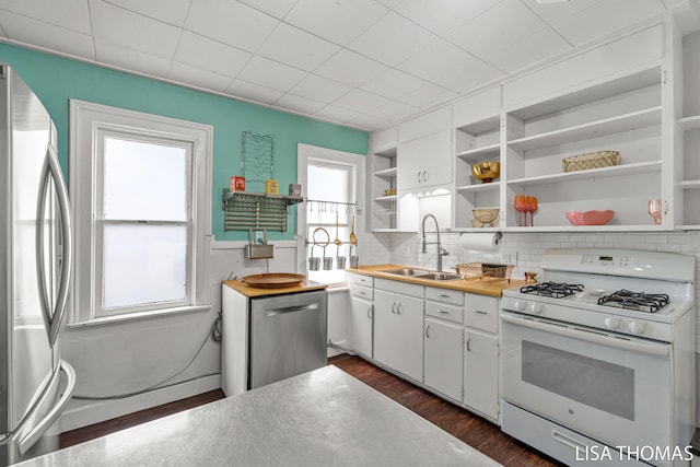 1000 Garfield Ave NW, Grand Rapids, MI 49504 - kitchen featuring stainless steel appliances, a sink, open shelves, dark wood-style floors, and white cabinets