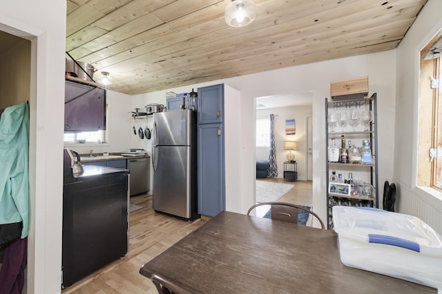 513 1st St, Manistee, MI 49660 - kitchen featuring freestanding refrigerator, blue cabinets, healthy amount of natural light, light wood finished floors, and wooden ceiling