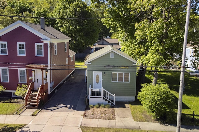 513 1st St, Manistee, MI 49660 - view of front of house featuring a chimney and asphalt driveway
