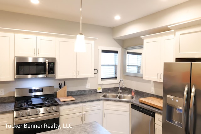 239 Monroe Ave, Muskegon, MI 49441 - kitchen featuring stainless steel appliances, a sink, white cabinetry, decorative light fixtures, and recessed lighting