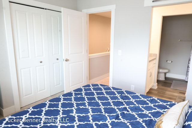 239 Monroe Ave, Muskegon, MI 49441 - unfurnished bedroom featuring a closet, ensuite bathroom, wood finished floors, and baseboards