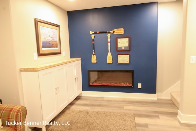 239 Monroe Ave, Muskegon, MI 49441 - corridor featuring light wood finished floors, stairway, and baseboards