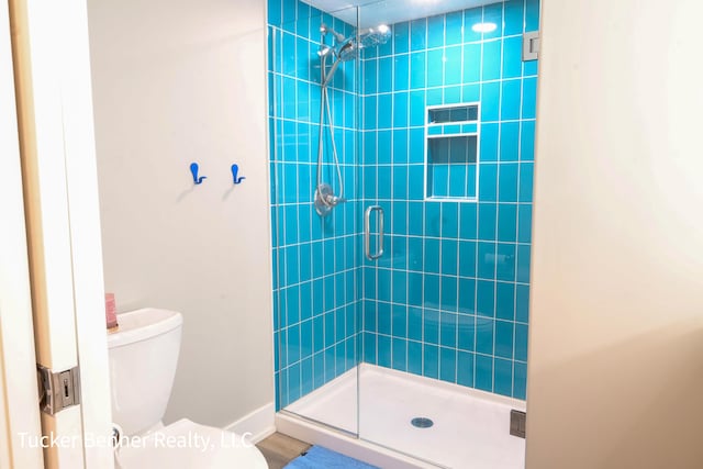 239 Monroe Ave, Muskegon, MI 49441 - bathroom with a stall shower, toilet, and baseboards