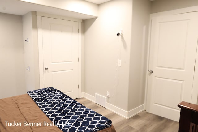 239 Monroe Ave, Muskegon, MI 49441 - bedroom with light wood finished floors, baseboards, and a closet