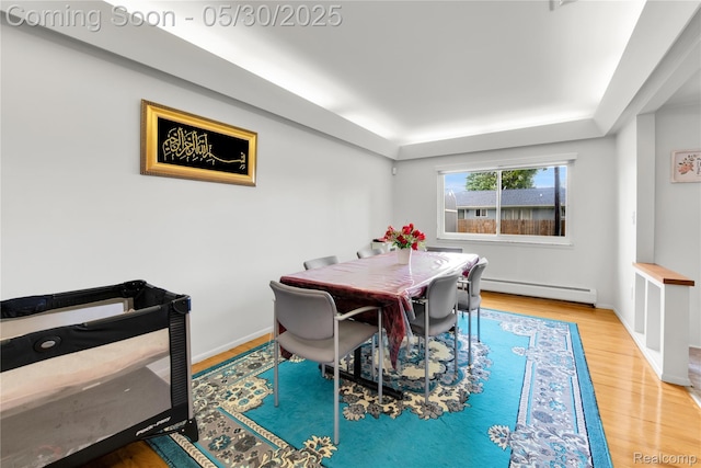 11030 Olive St, Warren, MI 48093 - dining space with a baseboard radiator, wood finished floors, a tray ceiling, and baseboards