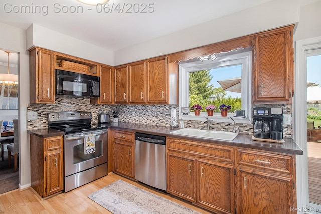 155 Woodridge Ct, Oxford, MI 48371 - kitchen with stainless steel appliances, a sink, dark countertops, and light wood finished floors
