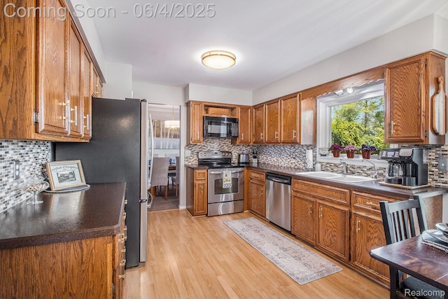 155 Woodridge Ct, Oxford, MI 48371 - kitchen featuring appliances with stainless steel finishes, a sink, brown cabinetry, and decorative backsplash