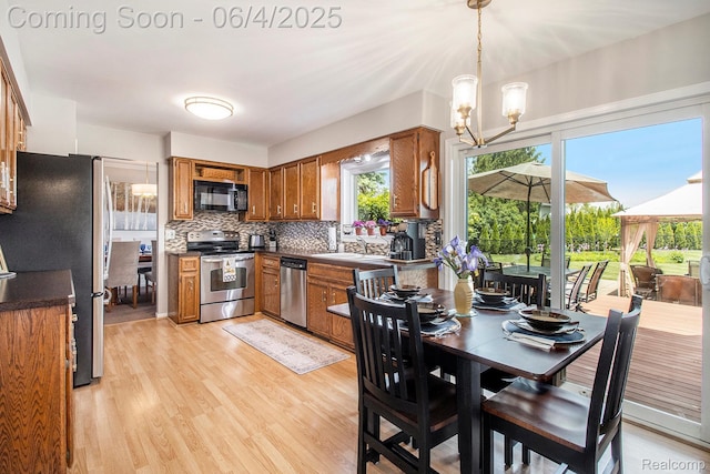 155 Woodridge Ct, Oxford, MI 48371 - dining space featuring a chandelier and light wood-style flooring