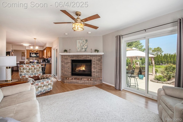 155 Woodridge Ct, Oxford, MI 48371 - living area featuring a chandelier, a ceiling fan, light wood-style flooring, and a fireplace