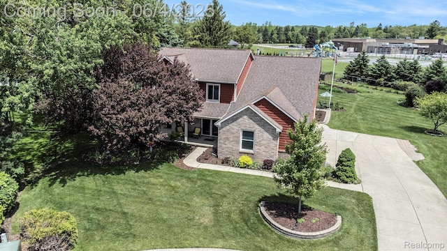 155 Woodridge Ct, Oxford, MI 48371 - view of front of house with a shingled roof, a front yard, and driveway