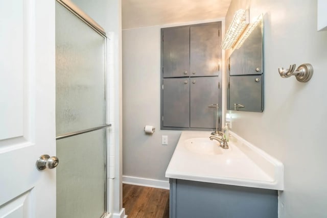 724 Wilson St, South Haven, MI 49090 - bathroom featuring vanity, an enclosed shower, baseboards, and wood finished floors