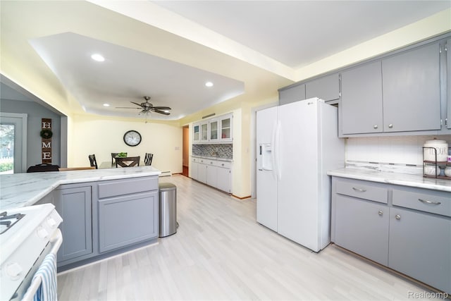 11523 Jenny Dr, Warren, MI 48093 - kitchen featuring white appliances, gray cabinets, a raised ceiling, recessed lighting, and backsplash