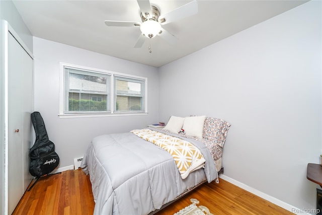 11523 Jenny Dr, Warren, MI 48093 - bedroom with a baseboard radiator, wood finished floors, baseboards, a closet, and a ceiling fan