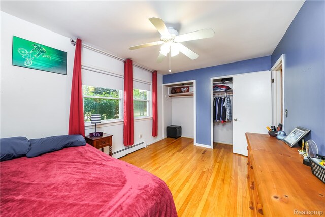 11523 Jenny Dr, Warren, MI 48093 - bedroom with baseboard heating, two closets, light wood-type flooring, and a ceiling fan
