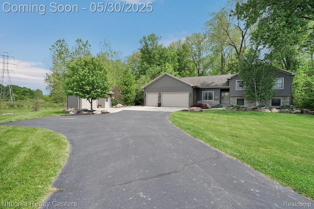 5257 Brookshire Dr, Almont, MI 48003 - tri-level home featuring a garage, driveway, a front yard, and stone siding