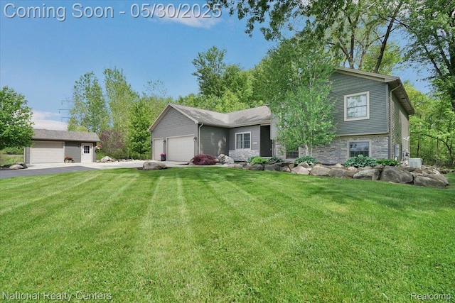 5257 Brookshire Dr, Almont, MI 48003 - tri-level home featuring stone siding, a front lawn, a garage, and driveway