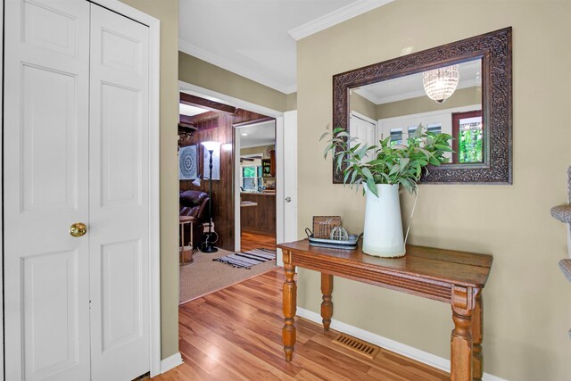1330 Kings Carriage Rd, Grand Blanc, MI 48439 - hallway featuring light wood finished floors, ornamental molding, baseboards, and a chandelier