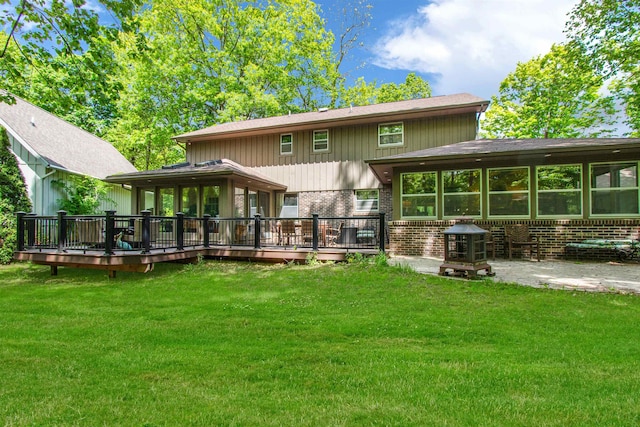 1330 Kings Carriage Rd, Grand Blanc, MI 48439 - back of house featuring brick siding, a deck, a yard, and a sunroom