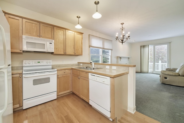 70 Spinnaker Dr, Manistee, MI 49660 - kitchen featuring white appliances, a sink, a peninsula, open floor plan, and plenty of natural light