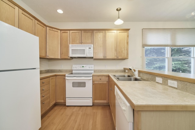 70 Spinnaker Dr, Manistee, MI 49660 - kitchen with white appliances, a sink, light wood-style flooring, light countertops, and decorative light fixtures