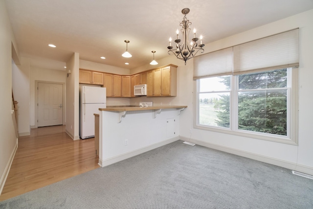 70 Spinnaker Dr, Manistee, MI 49660 - kitchen with white appliances, recessed lighting, a peninsula, a kitchen breakfast bar, and light brown cabinetry