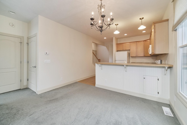 70 Spinnaker Dr, Manistee, MI 49660 - kitchen with freestanding refrigerator, light colored carpet, a peninsula, light countertops, and recessed lighting