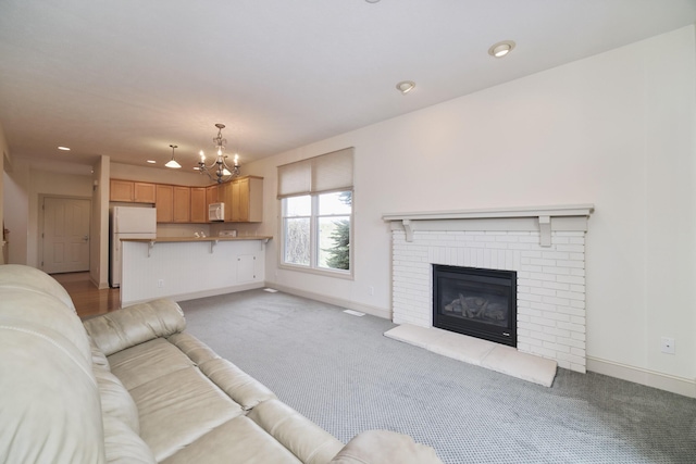 70 Spinnaker Dr, Manistee, MI 49660 - living area with light carpet, a chandelier, baseboards, recessed lighting, and a brick fireplace