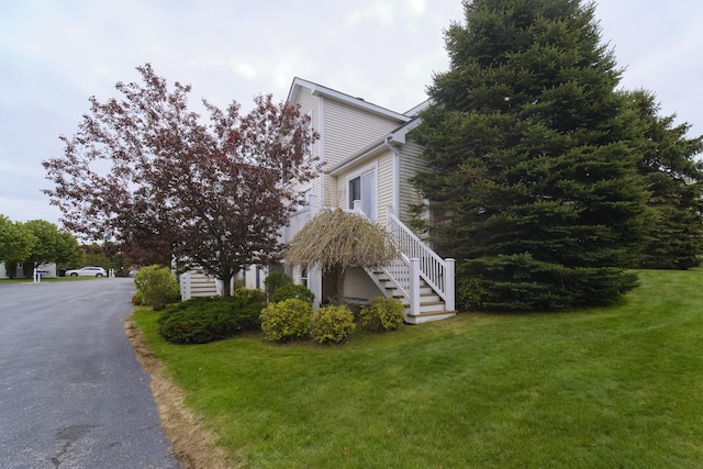 70 Spinnaker Dr, Manistee, MI 49660 - view of side of home with stairway and a lawn