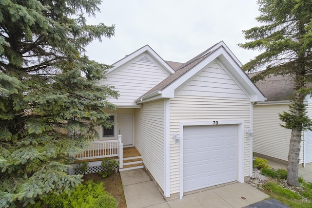70 Spinnaker Dr, Manistee, MI 49660 - ranch-style home featuring concrete driveway, a porch, a garage, and a shingled roof