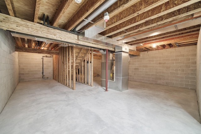 70 Spinnaker Dr, Manistee, MI 49660 - unfinished below grade area featuring stairs, concrete block wall, and heating unit