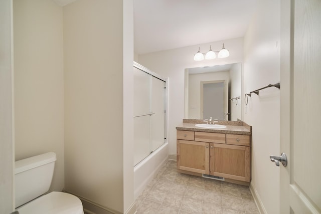 70 Spinnaker Dr, Manistee, MI 49660 - full bath featuring toilet, vanity, shower / bath combination with glass door, and baseboards