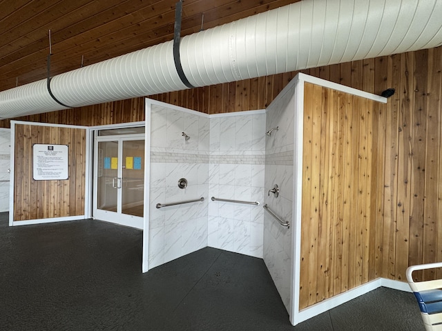 70 Spinnaker Dr, Manistee, MI 49660 - bathroom featuring a tile shower and wooden walls