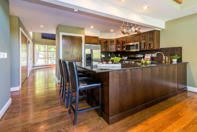 3007 Cedarbrook Rd, Ann Arbor, MI 48105 - kitchen with appliances with stainless steel finishes, a peninsula, a sink, decorative backsplash, and baseboards
