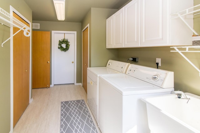 3007 Cedarbrook Rd, Ann Arbor, MI 48105 - washroom featuring cabinet space, independent washer and dryer, light wood-type flooring, and baseboards