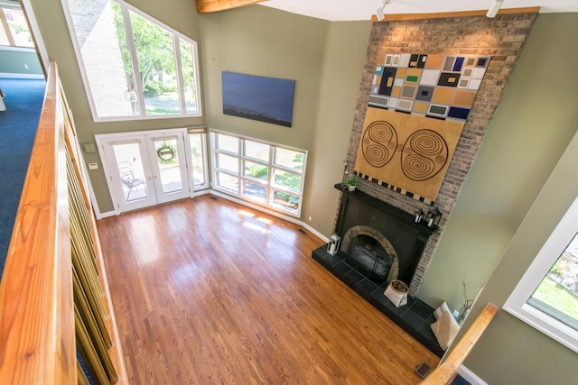 3007 Cedarbrook Rd, Ann Arbor, MI 48105 - living area featuring a high ceiling, wood finished floors, a fireplace with raised hearth, baseboards, and french doors