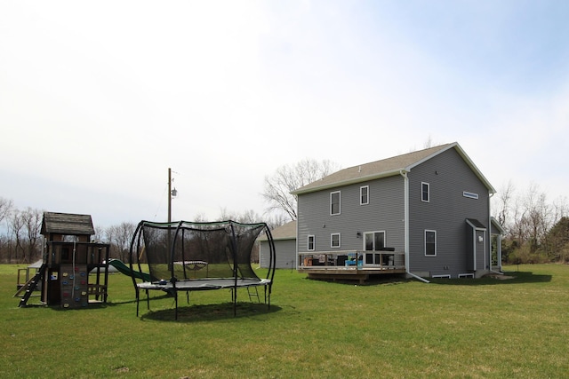 10141 S 33rd St, Vicksburg, MI 49097 - back of property featuring a trampoline, a wooden deck, a playground, and a yard