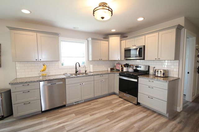 10141 S 33rd St, Vicksburg, MI 49097 - kitchen featuring appliances with stainless steel finishes, a sink, light wood-style flooring, decorative backsplash, and recessed lighting