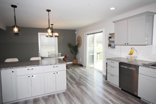 10141 S 33rd St, Vicksburg, MI 49097 - kitchen featuring stainless steel dishwasher, light wood-style flooring, tasteful backsplash, light stone counters, and pendant lighting