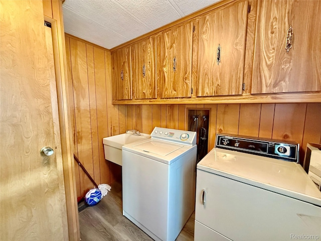 25654 Madison St, Novi, MI 48375 - laundry area with cabinet space, washing machine and dryer, wood finished floors, and wood walls