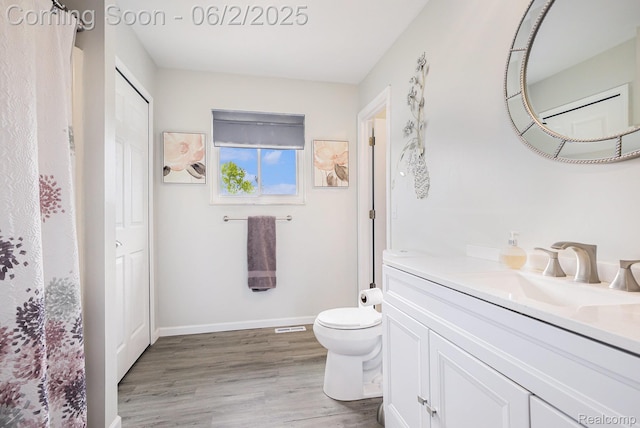7453 Baldwin Rd, Swartz Creek, MI 48473 - full bath featuring vanity, toilet, wood finished floors, baseboards, and curtained shower