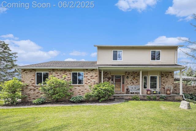 7453 Baldwin Rd, Swartz Creek, MI 48473 - traditional-style home featuring brick siding, a front yard, covered porch, and a shingled roof