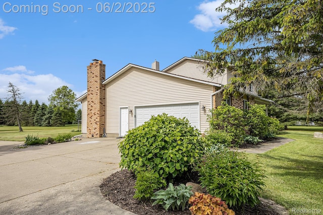 7453 Baldwin Rd, Swartz Creek, MI 48473 - view of side of property with a garage, a yard, driveway, and a chimney