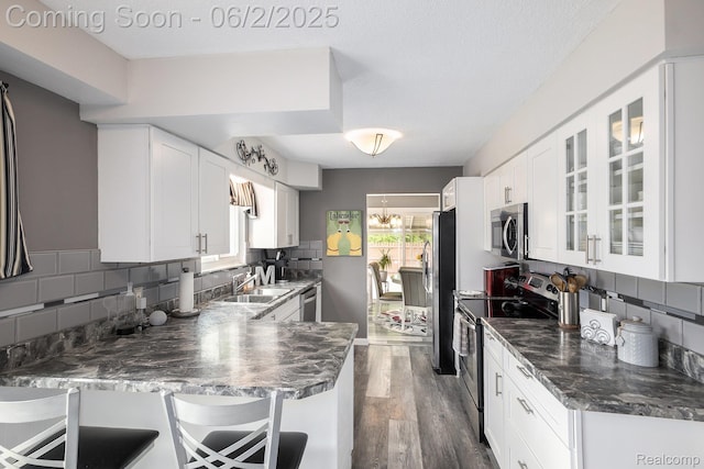 7453 Baldwin Rd, Swartz Creek, MI 48473 - kitchen featuring stainless steel appliances, a sink, backsplash, white cabinets, and dark wood finished floors