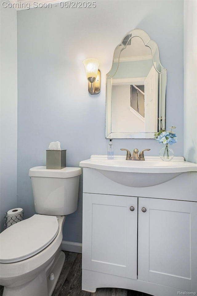 7453 Baldwin Rd, Swartz Creek, MI 48473 - bathroom featuring vanity, toilet, wood finished floors, and baseboards
