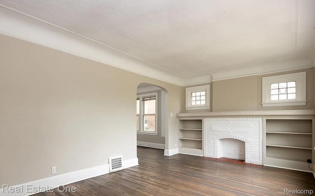 15344 Hartwell St, Dearborn Heights, MI 48227 - unfurnished living room featuring baseboards, arched walkways, wood finished floors, and a textured ceiling