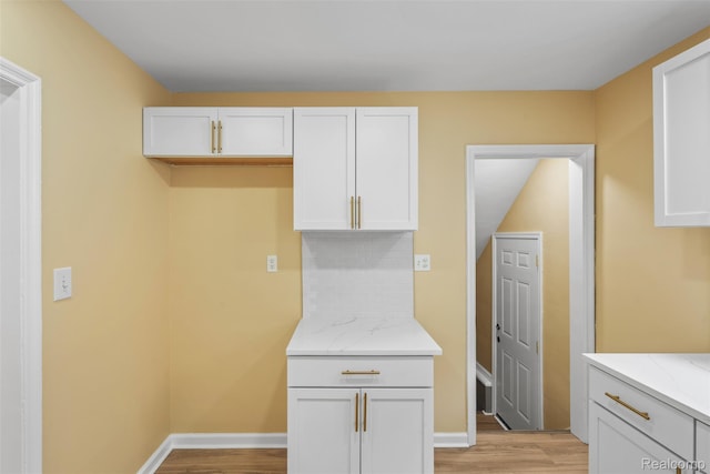 18696 Cherrylawn St, Detroit, MI 48221 - kitchen featuring light wood-style floors, light stone counters, white cabinets, and baseboards