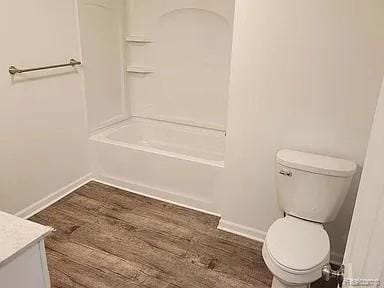 513 W Kilborn St, Lansing, MI 48906 - bathroom featuring vanity, wood finished floors, toilet, and baseboards